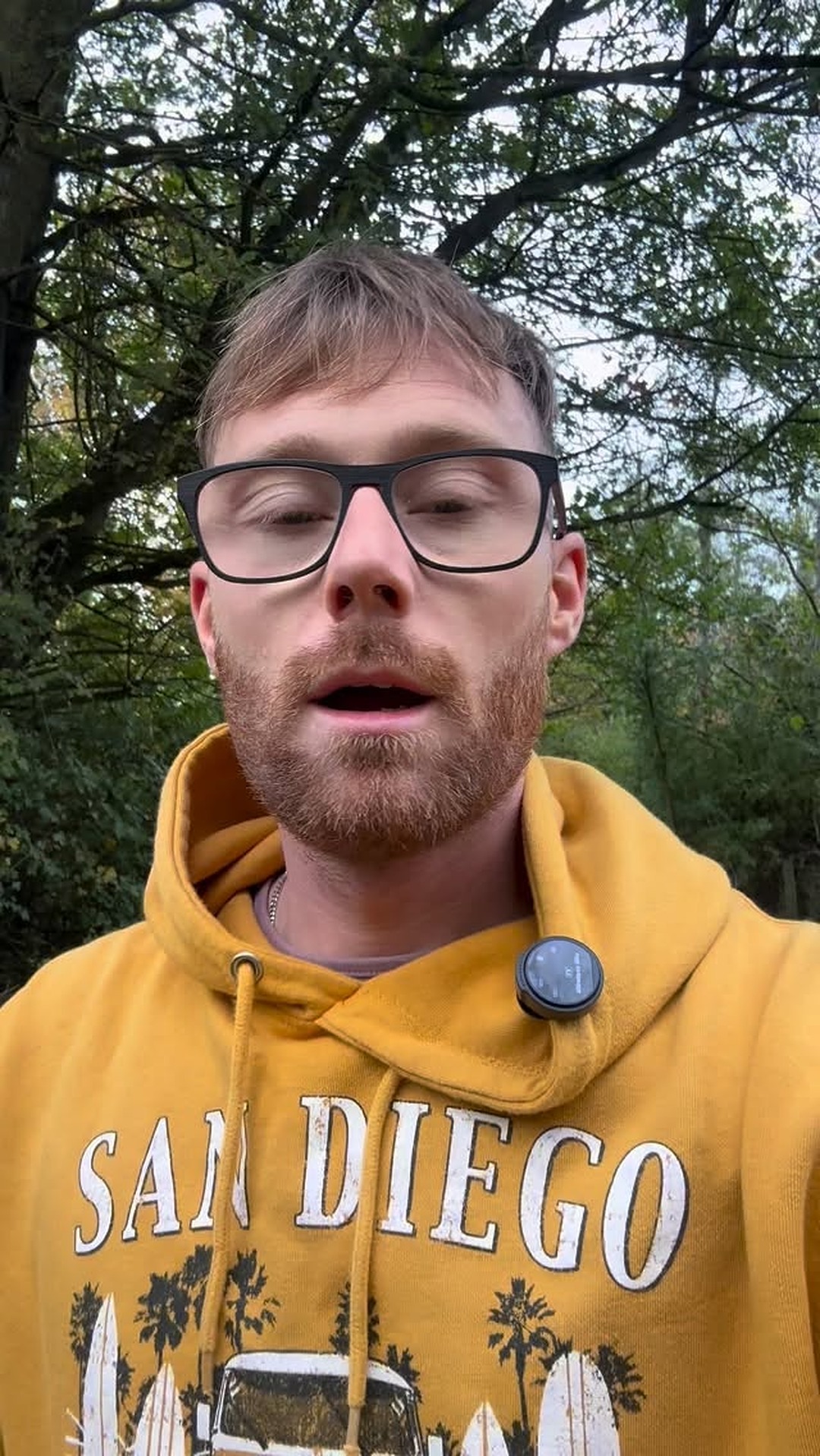 Kelvin outdoors in a yellow hoodie, close, looking into the lens.