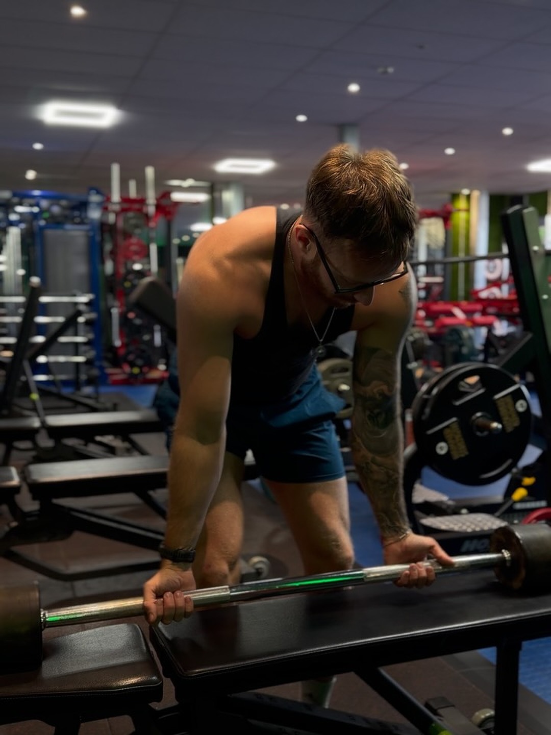 Kelvin working at the dumbbell rack on the gym floor.